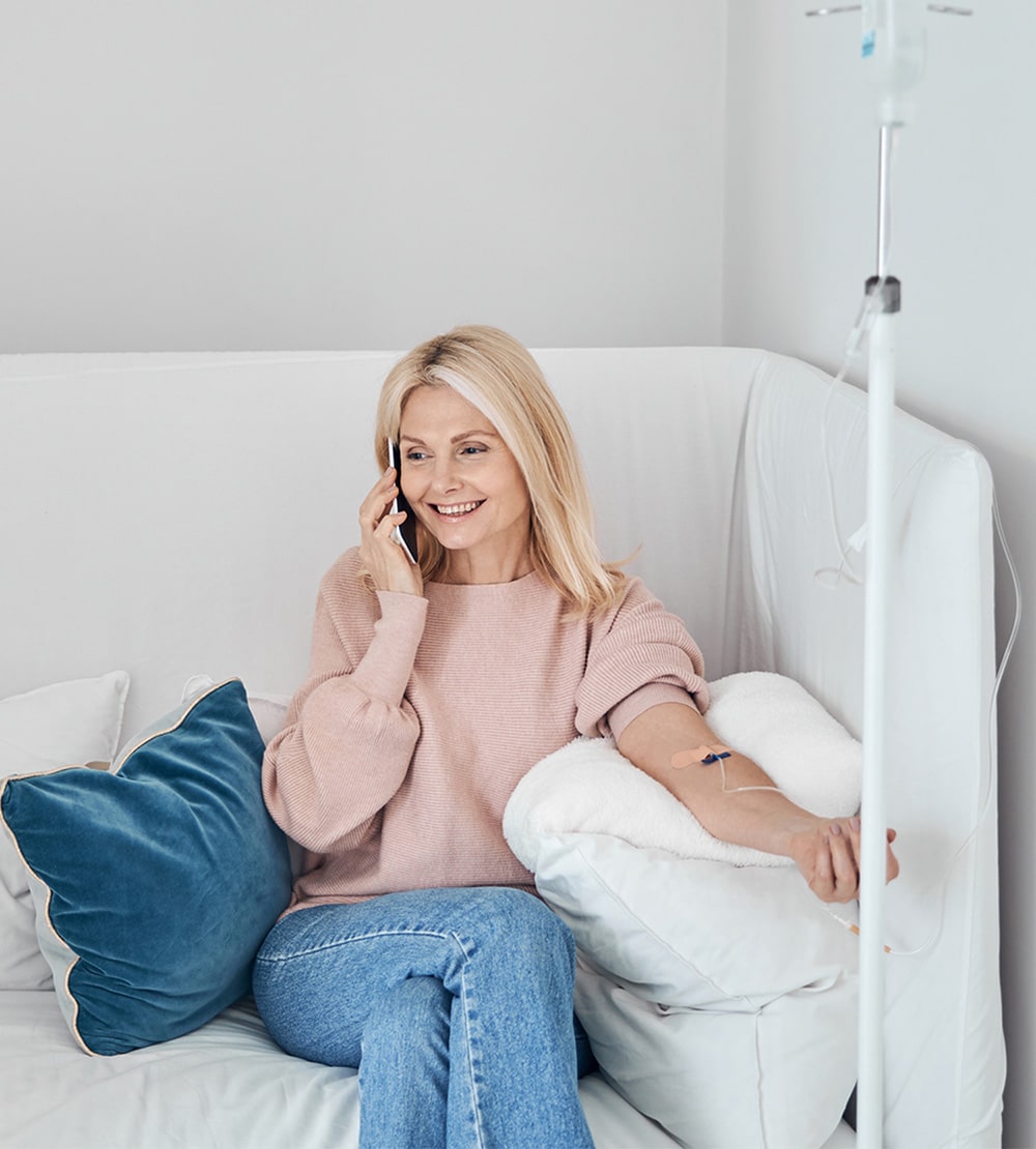 a woman sitting in a chair talking on a cell phone